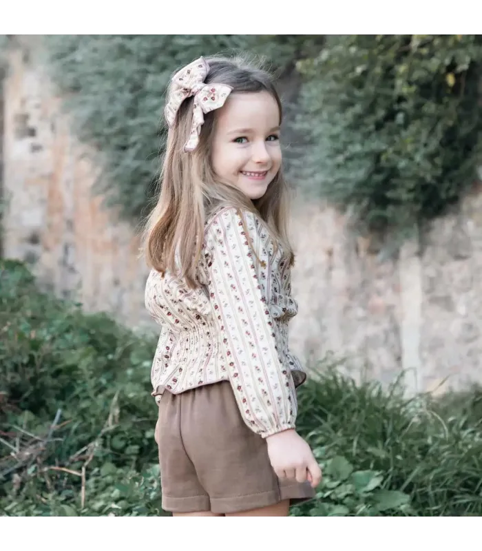 Niña vestida con el Conjunto niña arena algodón blusa floral rayas verticales con falda pantalón lisa reciclada