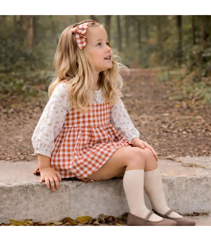 Niña con el Jesusito bebé terracota vichy vestido vuelo blusa algodón cuello volante pololo conjunto elegante