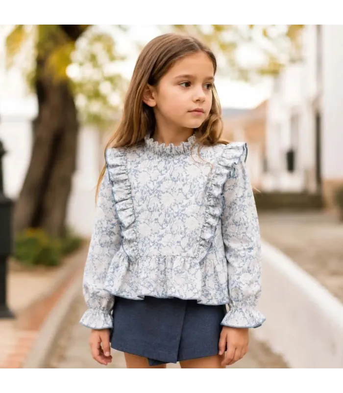 Niña con el conjunto niña azul toile blusa volantes falda pantalón textura detalle elegante