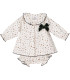 Vestido bebé navideño estampado con cuello volante y lazo verde. Fondo blanco.