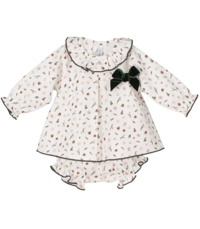 Vestido bebé navideño estampado con cuello volante y lazo verde. Fondo blanco.
