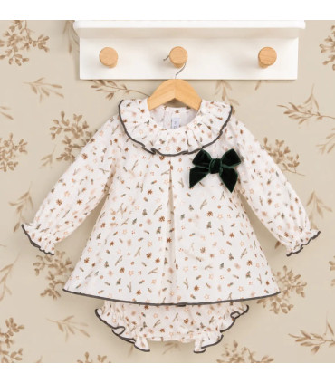 Vestido bebé navideño estampado con cuello volante y lazo verde. Fondo estudio