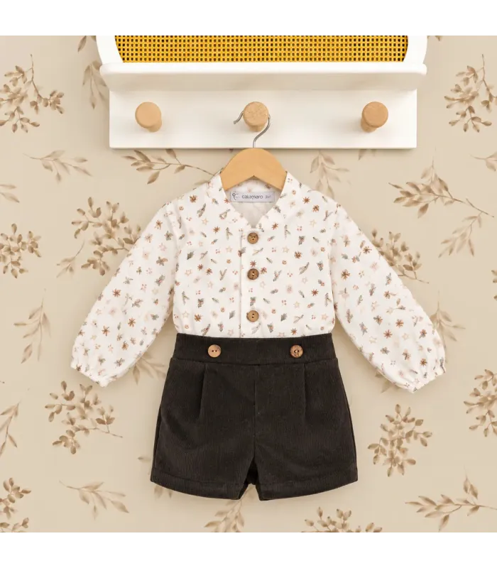 Conjunto bebé navideño con blusa estampada y pololo de pana oscuro. Fondo estudio.