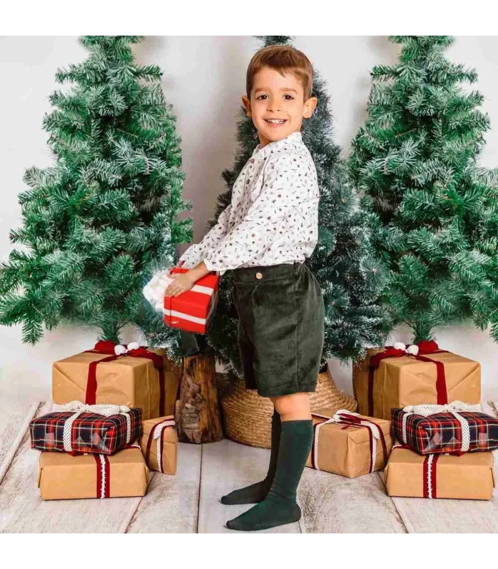Conjunto bebé navideño con blusa estampada y pololo de pana oscuro. Fondo blanco.