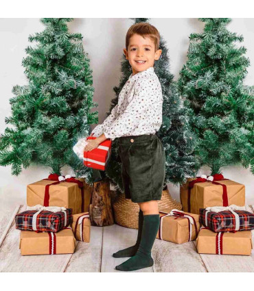 Conjunto bebé navideño con blusa estampada y pololo de pana oscuro. Fondo blanco.
