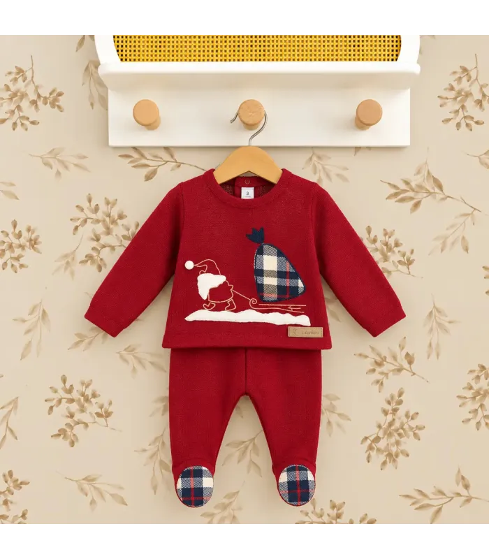 Conjunto de punto rojo para bebé con dibujo navideño de Papá Noel y reno. Fondo estudio.
