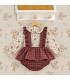 Conjunto bebé Del Sur con blusa floral y peto de cuadros granates. Fondo estudio.