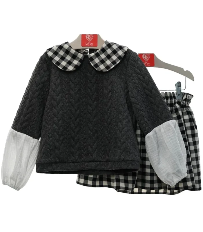 Conjunto Del Sur gris con falda de cuadros blancos y negros. Fondo blanco.