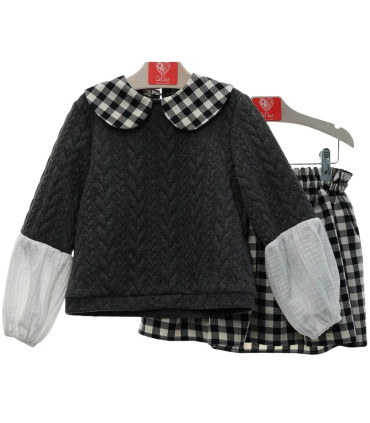 Conjunto Del Sur gris con falda de cuadros blancos y negros. Fondo blanco.