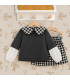 Conjunto Del Sur gris con falda de cuadros blancos y negros. Fondo estudio.