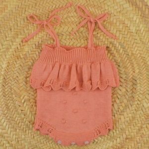body bebe coral dulce de fresa primor punto con lazos y volante tejido sobre fondo natural