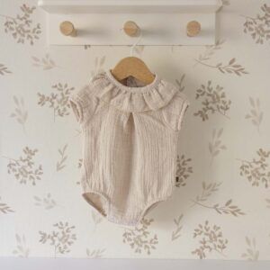 Ranita bebé arena Calamaro con cuello volante y tejido plumeti sobre fondo neutro