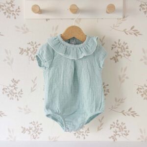 Ranita bebé turquesa Calamaro con cuello volante y tejido plumeti sobre fondo neutro