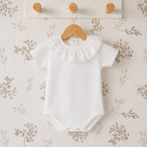 body bebé blanco plumetilla cuello volante algodón textura ligera detalle verano elegante