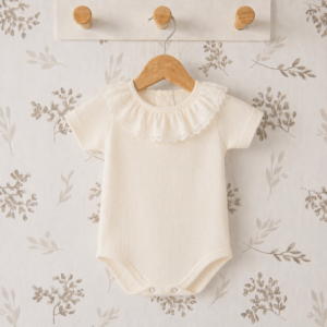 body bebé crudo plumetilla cuello volante algodón textura ligera detalle verano natural